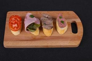 Bruschetta with tomato, ham and tongue photo