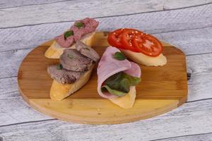 Bruschetta with tomato, ham and tongue photo