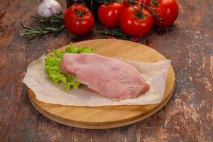 Raw Turkey steak served rosemary photo