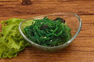 Green Chuka Seaweed Salad Isolated on White Background Top View. Wakame Sea Kelp Salat photo