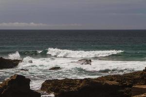 The waves fighting about deserted rocky coast of Atlantic ocean, Portugal photo