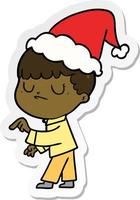 sticker cartoon of a grumpy boy wearing santa hat vector