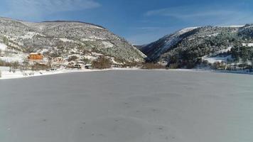 lago ghiacciato e neve. vista del lago ghiacciato e del terreno innevato. video