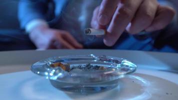 Close-up ashtray, burning cigarette. Smoker man puts cigarette in ashtray. video