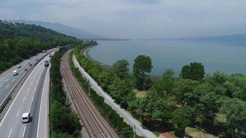carretera y ferrocarril. Carretera y vía del tren ubicada junto al lago, vista al transporte.