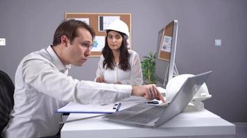 två ingenjörer som arbetar med projektet. två ingenjörer som arbetar med ett projekt på jobbet. en är kvinna och en är man. video