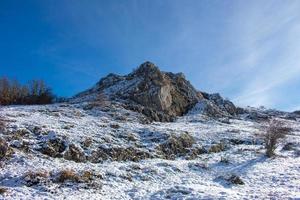 montaña cubierta de nieve con cielo azul en un día soleado foto