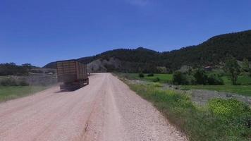 Truck on dirt road, logistics. The truck is driving on the dirt road. Dusty and smoky. video