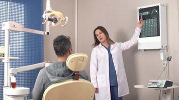 tandarts en röntgenfoto. de tandarts legt haar patiënt uit via röntgenfoto's. video