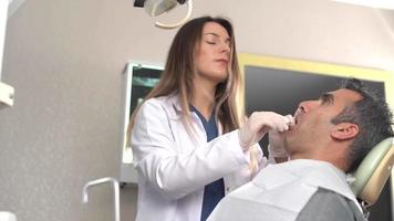 dentista guardando il dente del paziente. il dentista guarda il dente del paziente e fa una spiegazione sulla radiografia. video