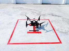 drone negro preparándose para volar en el estacionamiento y en el edificio. tecnología, dispositivo y avioneta foto