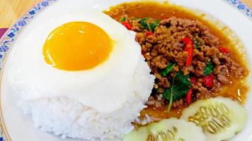 Thai spicy food. Basil fried rice with minced meat and fried egg on top.  Fried egg focused photo