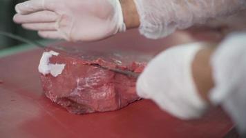 il coperchio taglia la carne. vitello. macellaio che taglia la carne della coscia di vitello. video