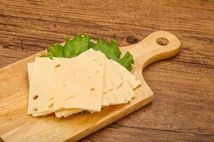 Sliced yellow cheese over board photo