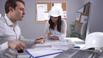 ingenieros trabajando en el proyecto. dos ingenieros trabajando en un proyecto en el trabajo. uno es hembra y el otro es macho. video