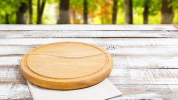servilleta y tabla para pizza en primer plano de escritorio de madera, mantel. lienzo, paños de cocina en la vista superior de fondo de mesa de madera blanca simulacro. enfoque selectivo foto