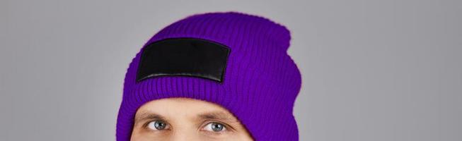 hipster in violet hat isolated on grey,cropped image photo