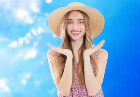 Beautiful asian woman withsummer hat smiling on a background of blue sky - summer concept photo