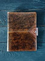 leather handmade notebook on dark wooden background photo