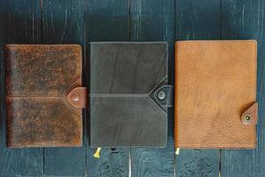 leather handmade notebooks organizer on dark wooden background photo