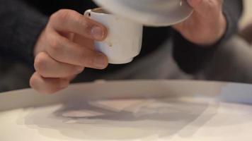 predizione del futuro, tazza di caffè. capovolge la tazza di caffè per predire il futuro. l'indovino scuote la sua tazza di caffè. video