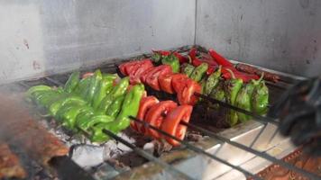 Grilled peppers, tomatoes. The chef is roasting peppers and tomatoes on the grill.