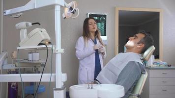 läkaren kontrollerar patientens tänder. läkaren kontrollerar patientens tänder och ger information om tillståndet på deras tänder via röntgen. video