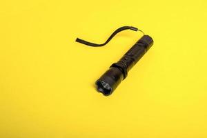 black flashlight shocker on a yellow background photo