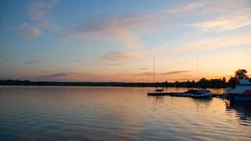 barcos en el lago al fondo de la puesta de sol. foto