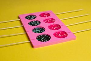 lollipops on a stick in a single form for cooking on a yellow background. photo