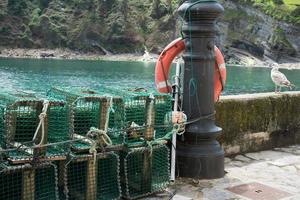 jaulas de pesca vacías, socorrista y gaviota. muelle de tazones, asturias foto