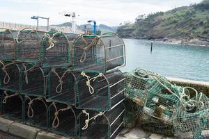 montón de jaulas y redes de pesca vacías. muelle de tazones, asturias foto