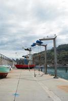 Tazones dock with two boats out of the water. Harbor cranes and seagulls. Asturias