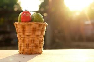 Fresh tomatoes and pumpkin in a basket made of bamboo leaves. photo