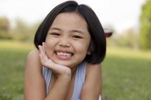 Asian little girl relax and smiling happily in the park photo