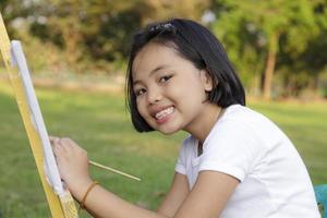 Asian little girl painting in in the park photo