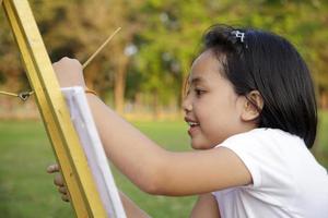 Asian little girl painting in in the park photo