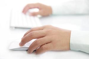 mano usando el mouse y el teclado de la computadora foto