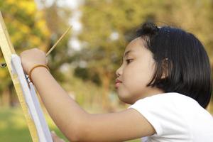 niña asiática pintando en el parque foto