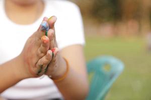 Asian little girl with hands painted in colorful paints photo