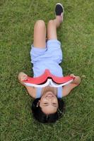 Asian little girl reading book in the park photo