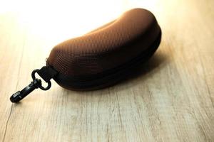 Brown glasses case on a wooden table photo