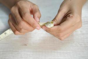 Female hand measuring finger with a tape measure photo