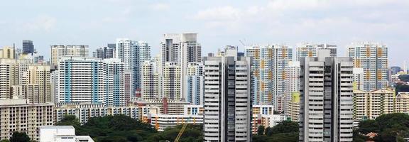 Cityscape of many modern tall skyscraper condominiums, apartments, with houses in foreground. buildings, singapore, city area. photo