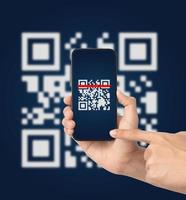 mano usando el código qr de escaneo de teléfono inteligente móvil. lector de código de barras, pago con código qr, tecnología sin efectivo, concepto de dinero digital foto