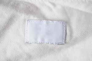 etiqueta de ropa blanca en blanco para el cuidado de la ropa en la camisa de algodón foto