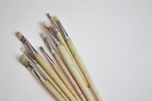 pinceles de diferentes tamaños con mangos de madera y cerdas naturales sobre fondo blanco. espacio libre para texto. foto
