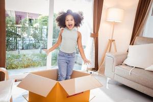 Funny African American little girl inside a paper box - children play photo