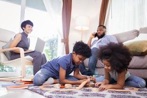 Happy African American family. little boy and girl having fun and play toys in the living room photo