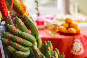 Banana Kluay Hom group with red Chinese characters stickers, which means Double happiness. Orange fruits and various offerings they were arranged on table covered with red cloth to bring good fortune. photo